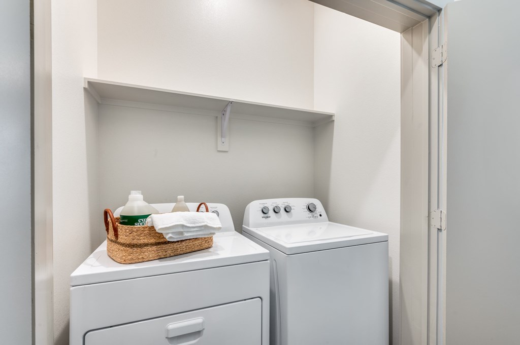 A laundry room with a basket of clean clothes on top of a washing machine.