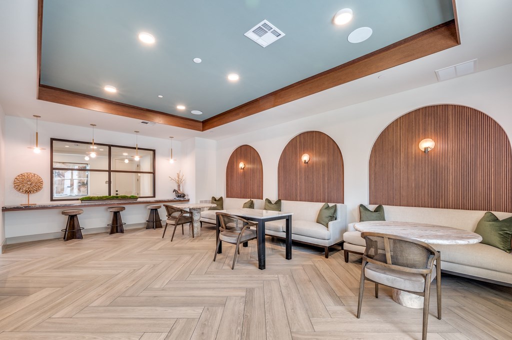 A modern living room with a wooden floor and white furniture.