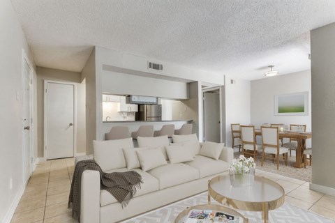 A living room with a white couch and a coffee table.