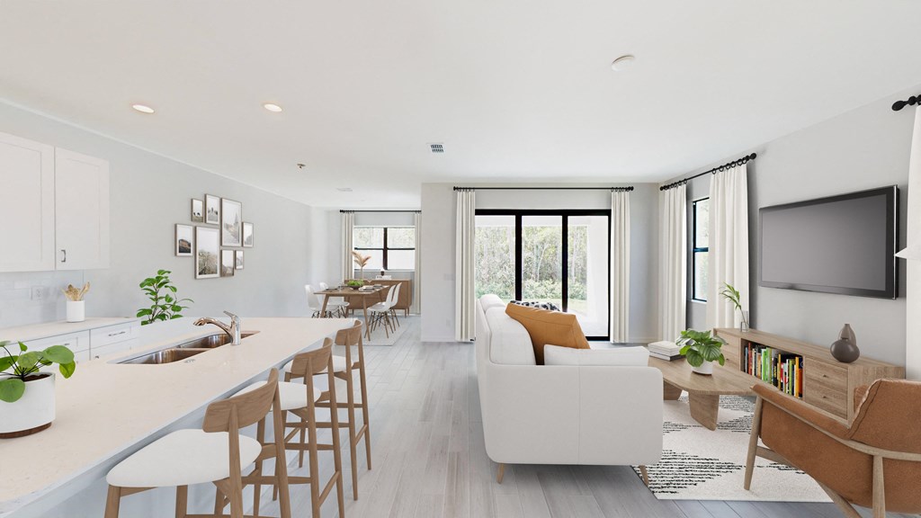 a living room with a white couch and a kitchen with a table and chairs