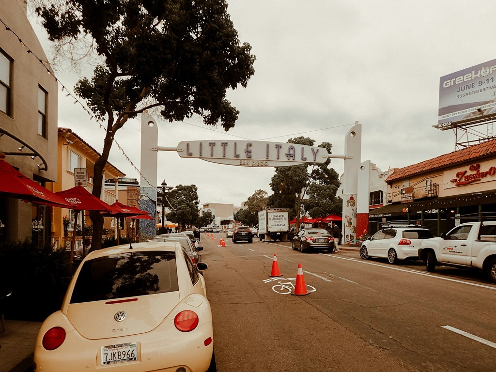 a city street with cars and a sign for little