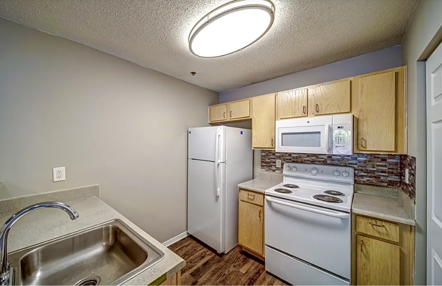 a kitchen with white appliances and a sink and a refrigerator