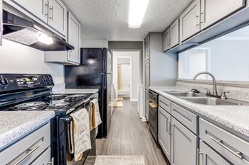 A kitchen with a black stove top oven and a black refrigerator.