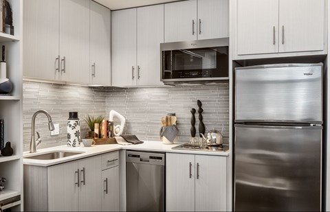 A modern kitchen with stainless steel appliances and white cabinets.