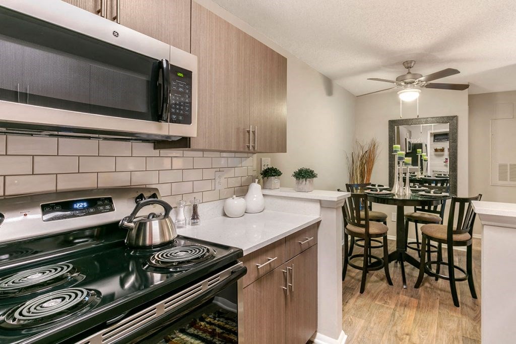 a kitchen with a stove top oven next to a kitchen counter with a table and chairs