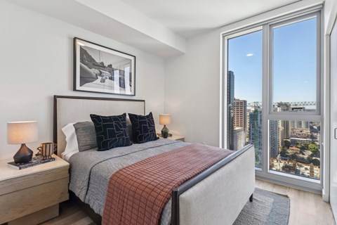 A bedroom with a large bed and a view of the city.