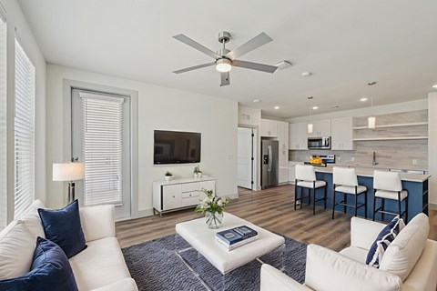 A living room with a white couch and a ceiling fan.