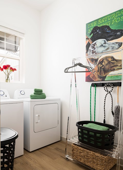A laundry room with a basket on the floor and a washing machine to the left.