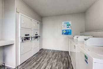 A laundry room with a washer and dryer and a sign on the wall.