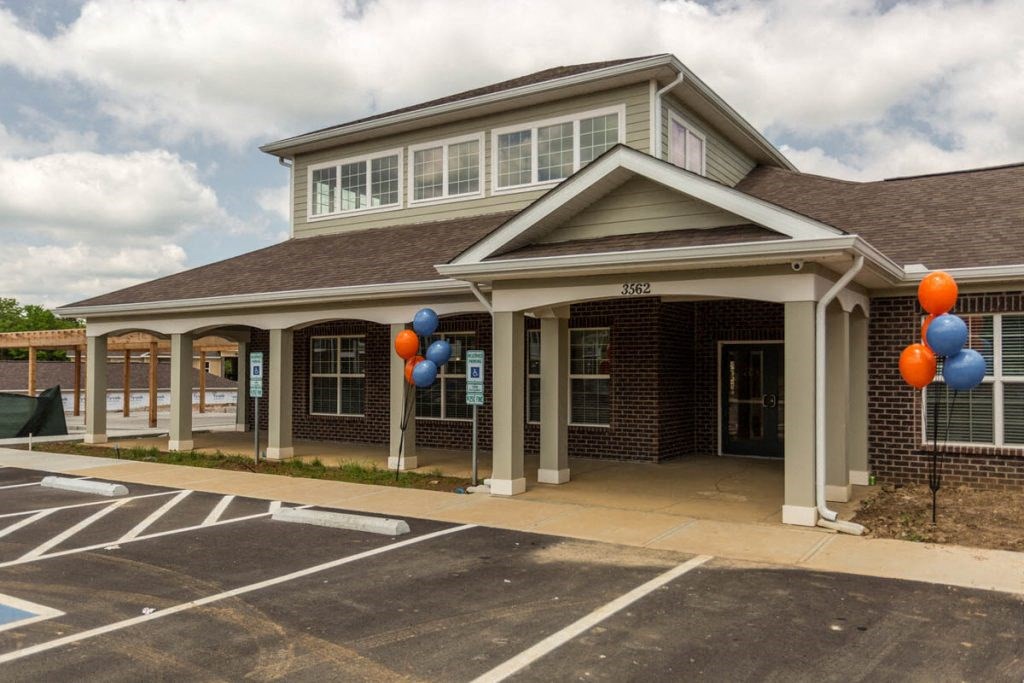 the front of a building with balloons outside of it
