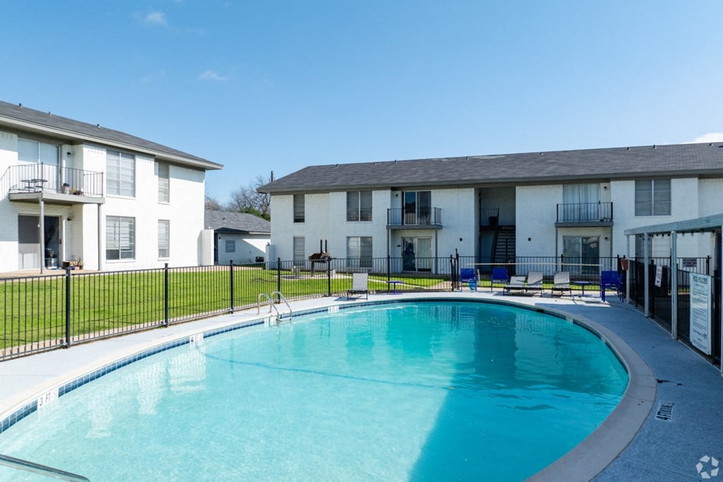 A swimming pool in front of apartment buildings.