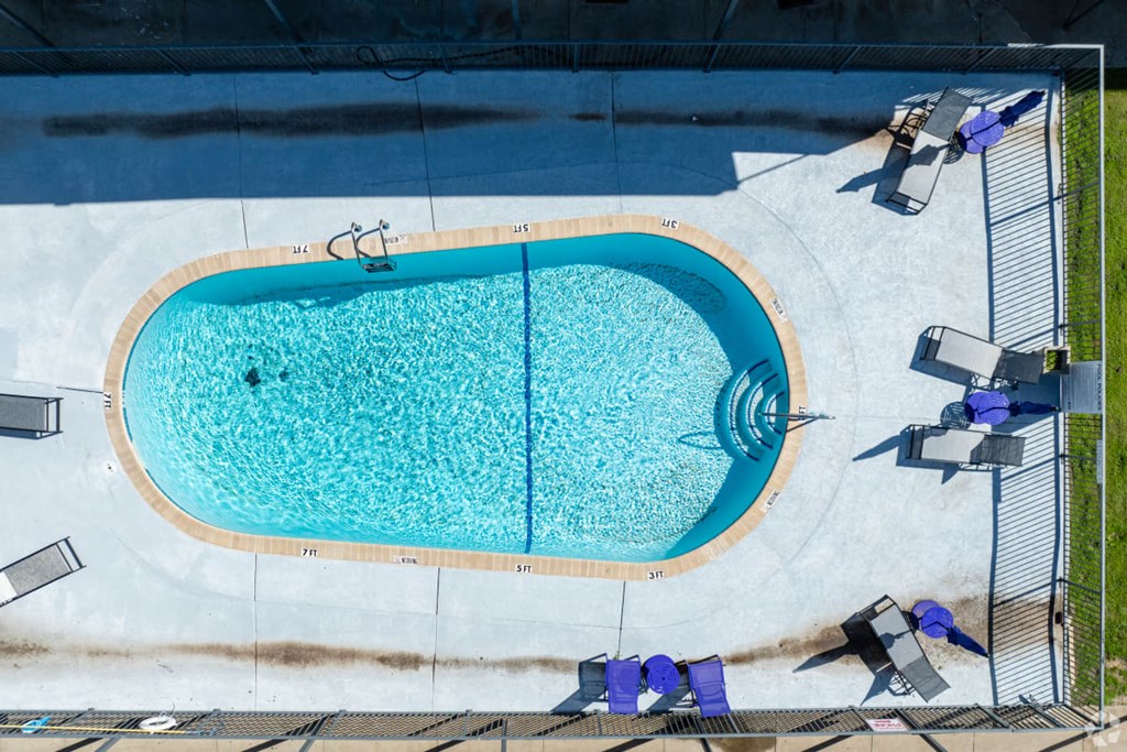 An aerial view of a swimming pool surrounded by a fence.
