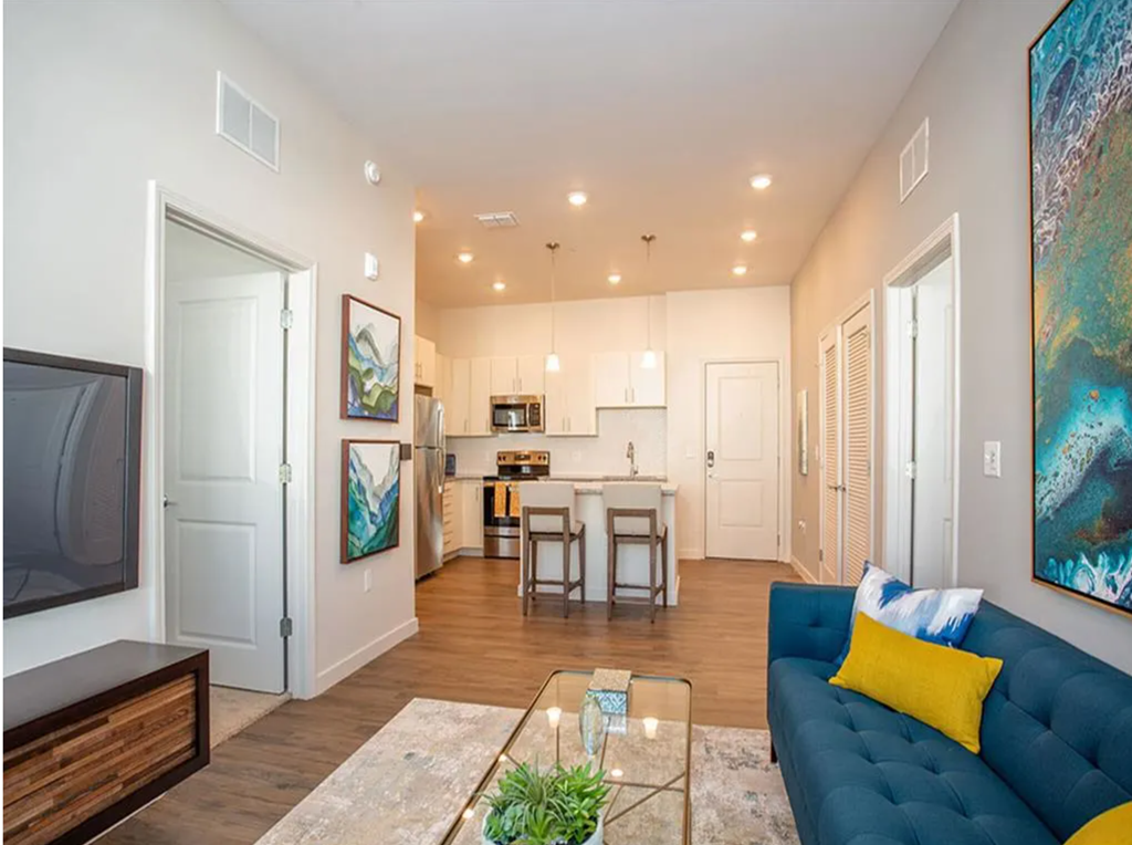 a living room and kitchen with a couch and a table