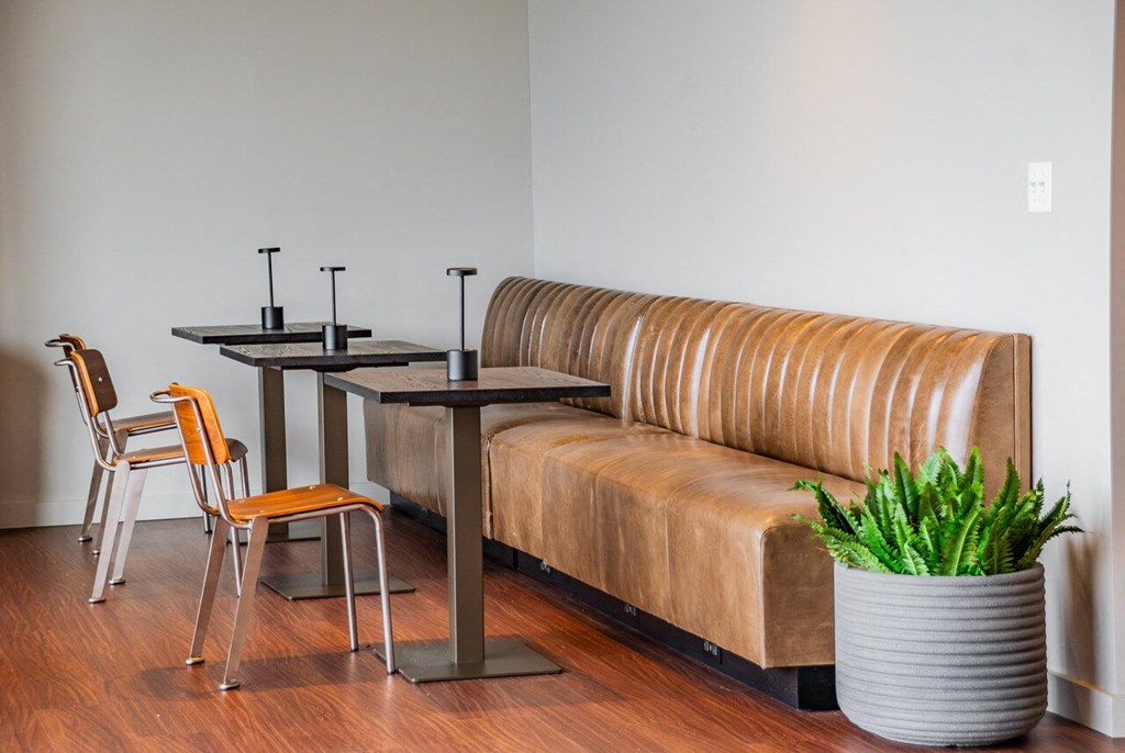 a seating area with a leather couch and tables