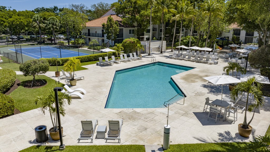a swimming pool with chairs and umbrellas at the resort