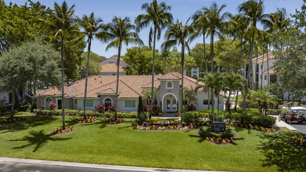 a home is shown with palm trees and a green lawn