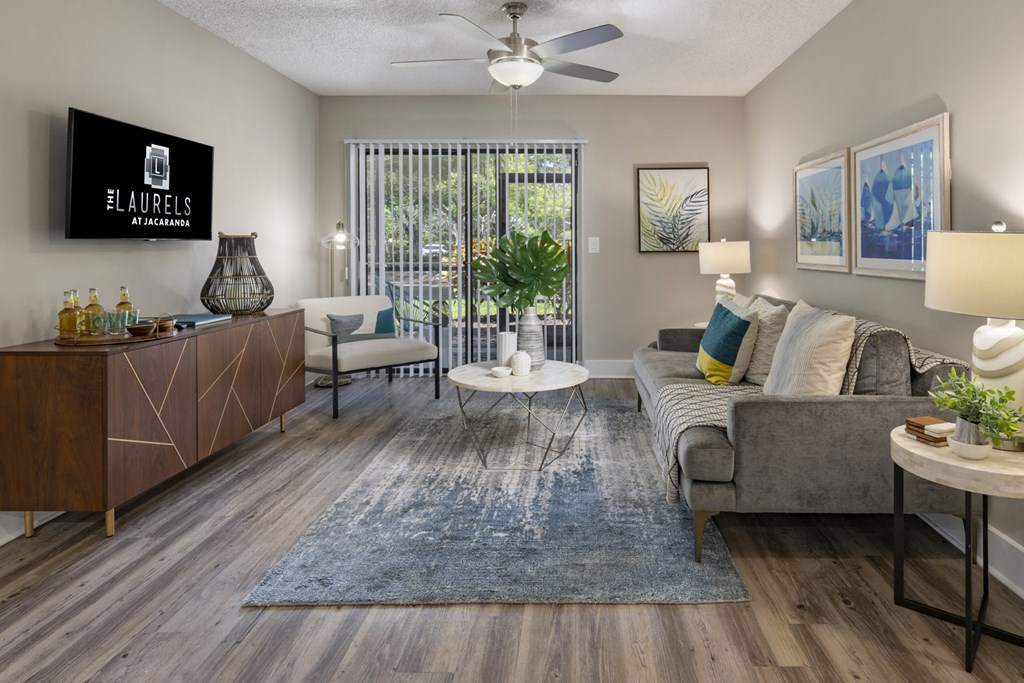 a living room with a couch and a table and a ceiling fan