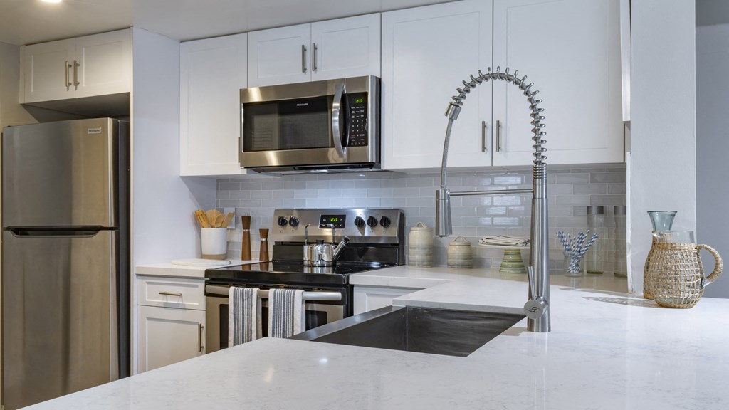 a kitchen with stainless steel appliances and white cabinets