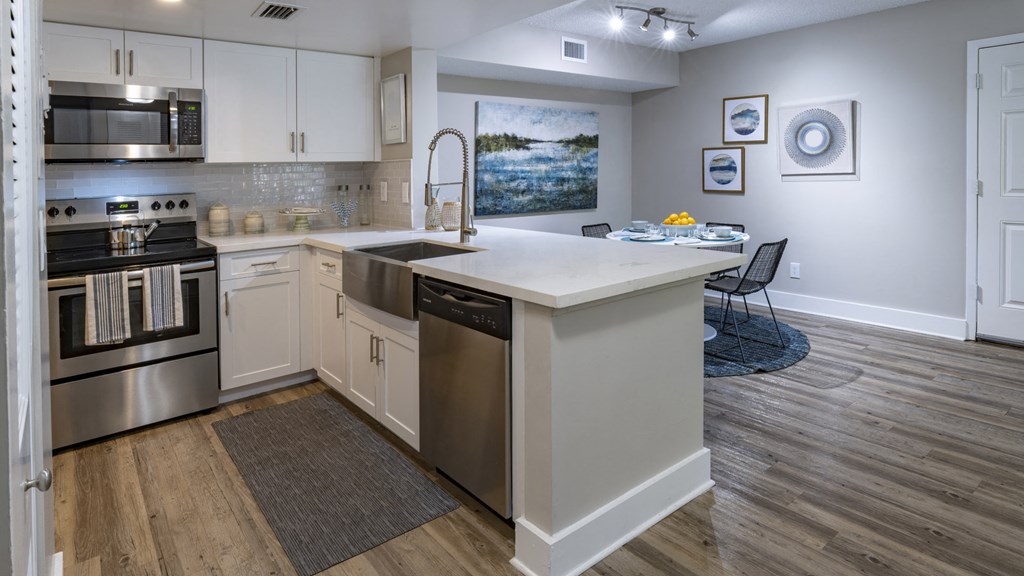 an open kitchen with a large island and stainless steel appliances