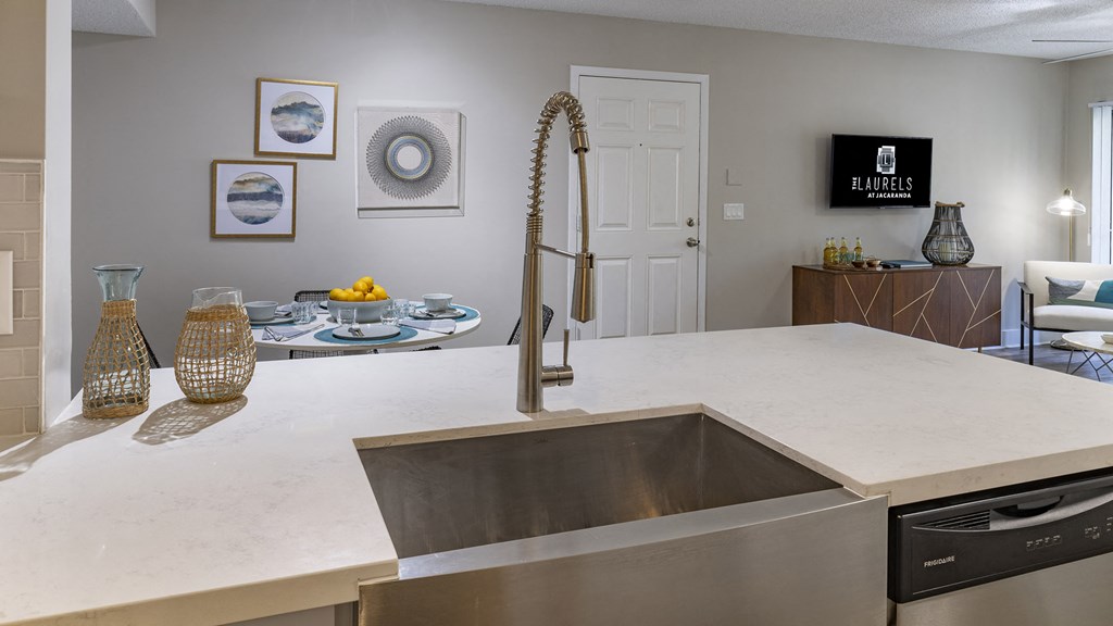 an open kitchen with a sink and a large counter top