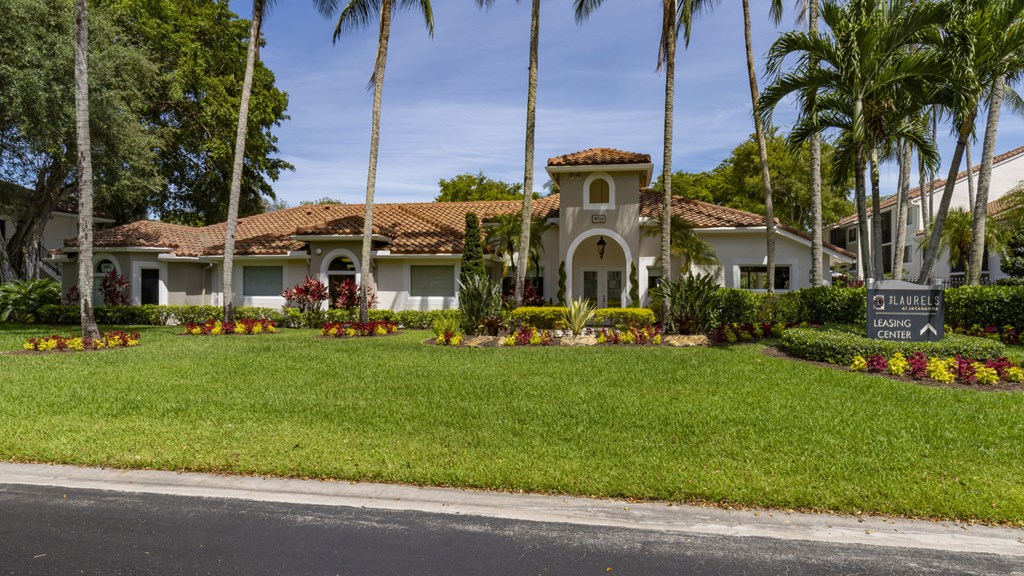 a house with palm trees and a sign in front of it