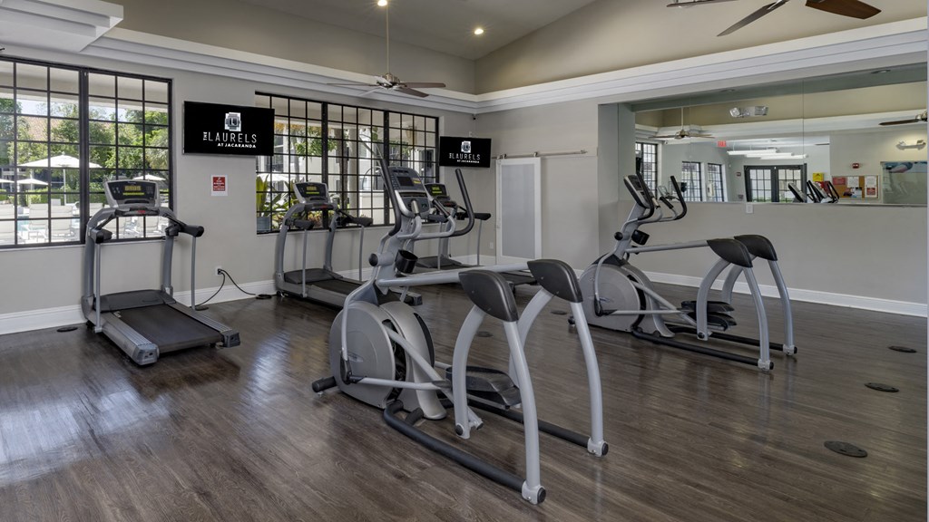 a gym with treadmills and other exercise equipment in a clubhouse