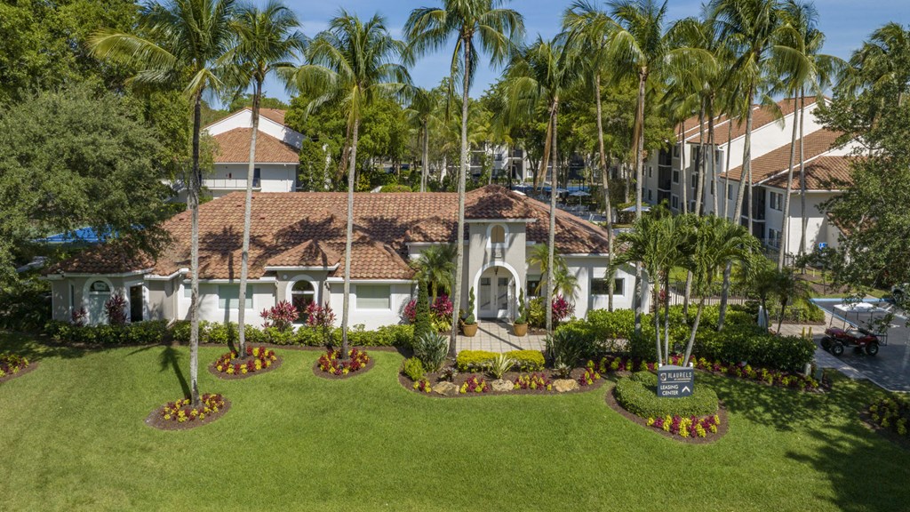 a mansion with a green lawn and palm trees