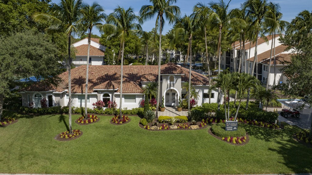 a mansion with a green lawn and palm trees