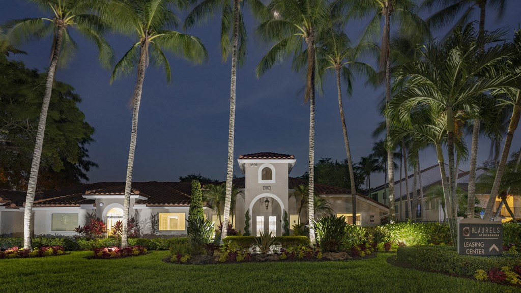 a house with palm trees in front of it at night