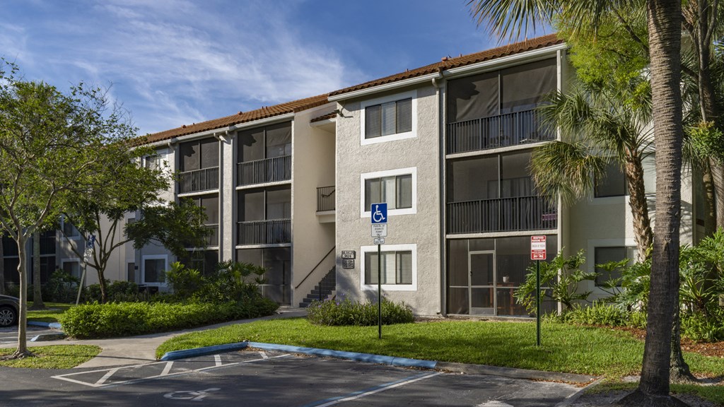an apartment building with a parking lot and palm trees