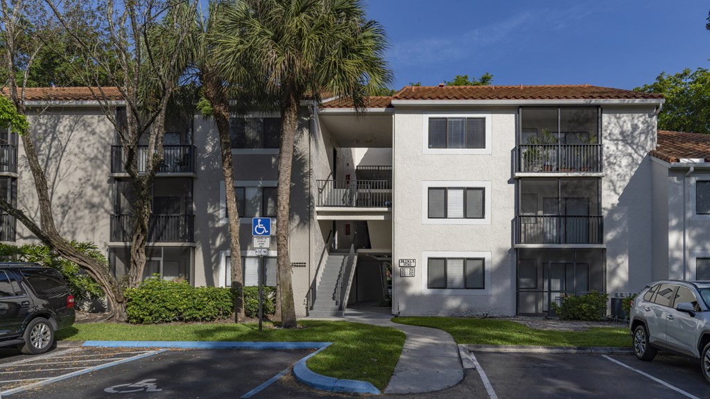 a white apartment building with palm trees in front of it