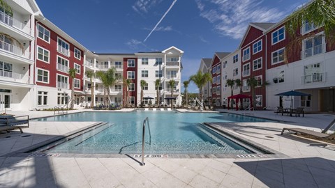 A large swimming pool in front of apartment buildings.