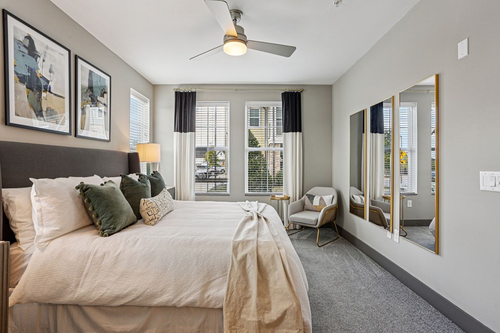 A bedroom with a large bed and a ceiling fan.