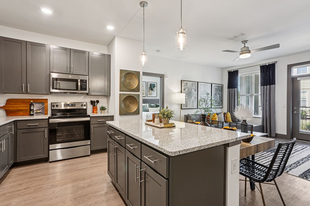A modern kitchen with a large island and stainless steel appliances.