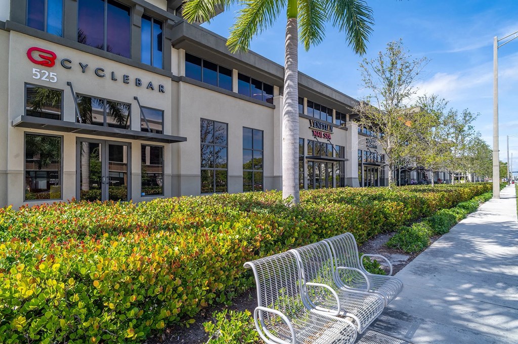 a bench in front of a building with palm trees