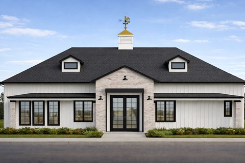 A white house with a black roof and a weather vane on top.