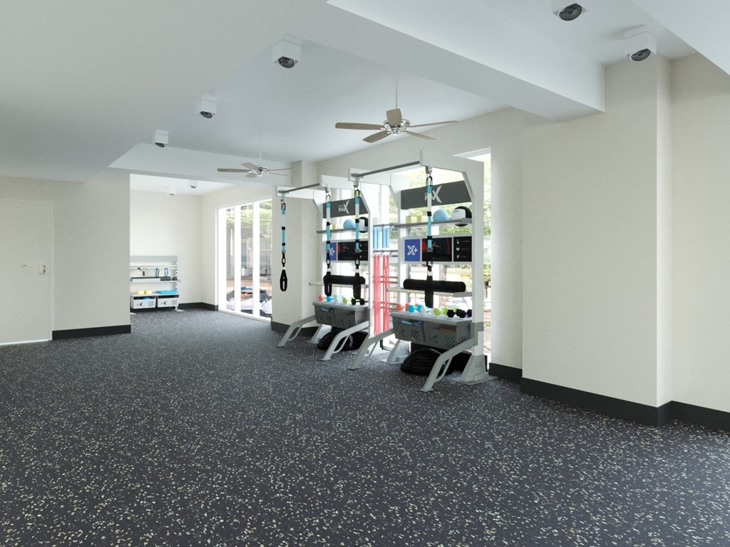 A spacious room with a grey carpet and a ceiling fan.