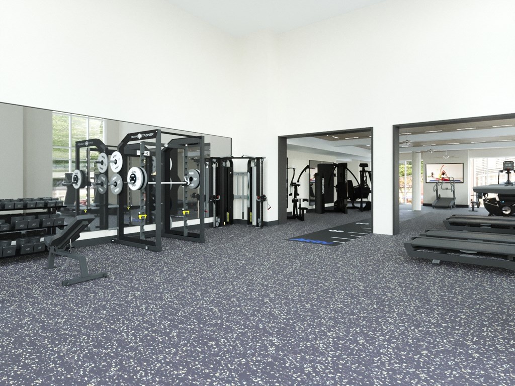 A gym with a variety of equipment including treadmills, weights, and exercise machines.