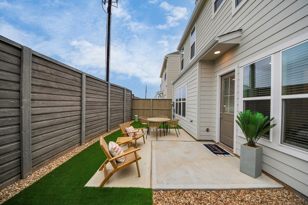 A backyard with a wooden table and chairs.