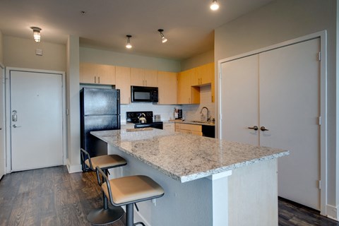 a kitchen with a granite counter top and a black refrigerator
