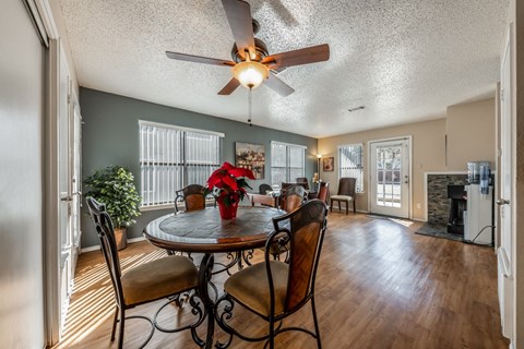 a dining room with a table and chairs and a ceiling fan