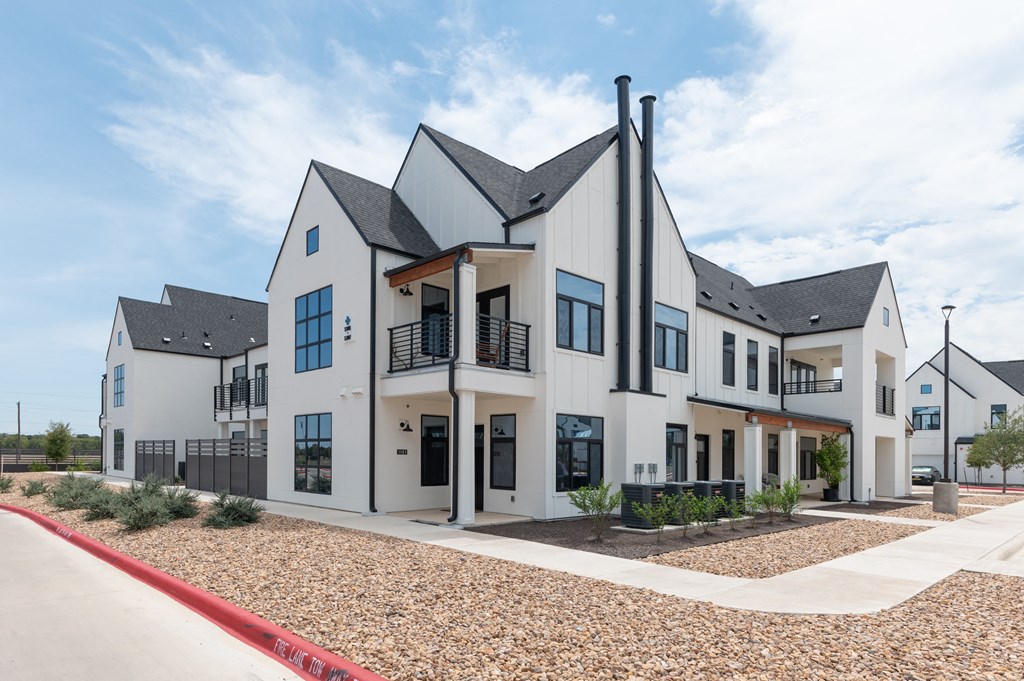 A modern house with a white exterior and black roofing.