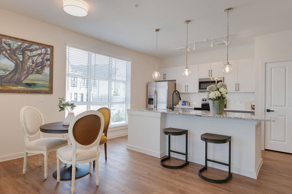 A kitchen with a bar and chairs.