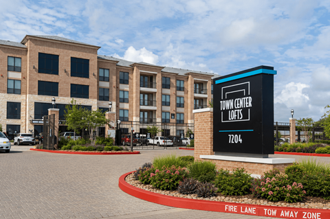 A sign for the Town Center Lofts is in front of a building.
