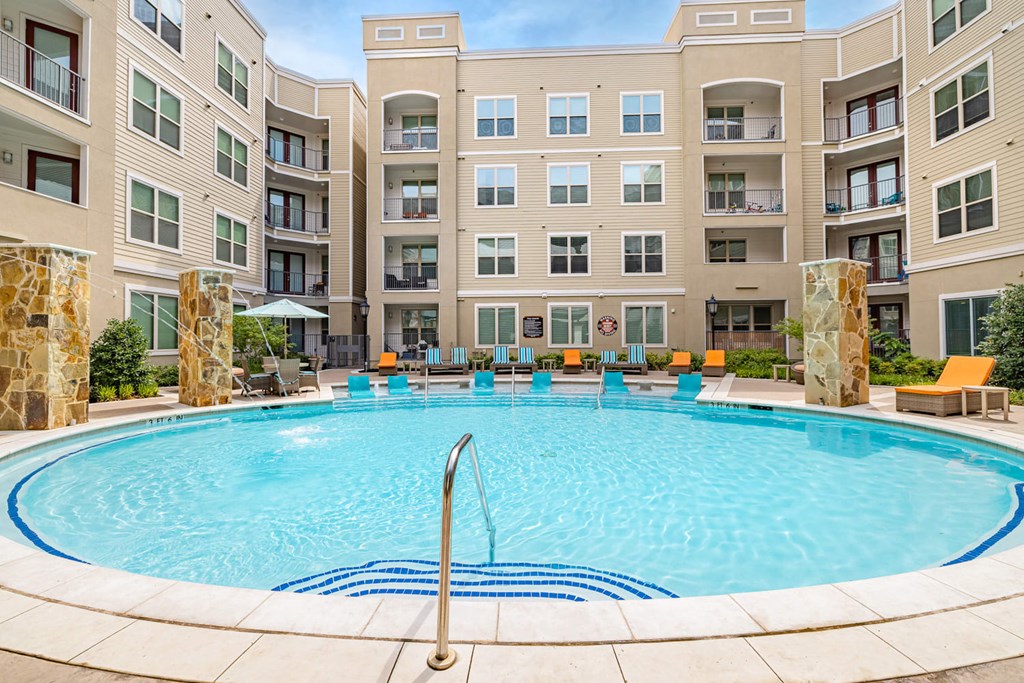 a swimming pool with an apartment building in the background