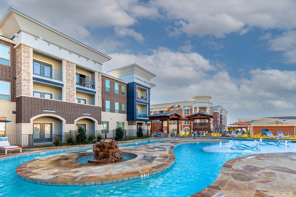 a swimming pool with a water feature in front of a building