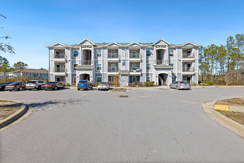 an empty parking lot in front of an apartment building