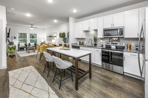 A modern kitchen with a dining table and chairs.