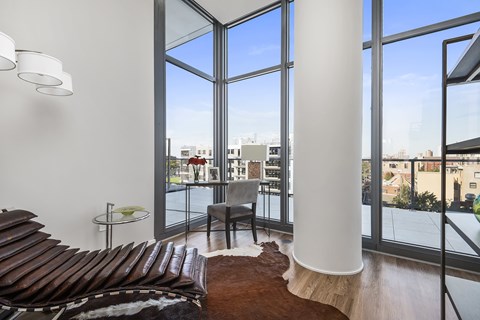 A living room with a brown couch and a white column.