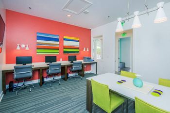 a conference room with desks and chairs and a red wall